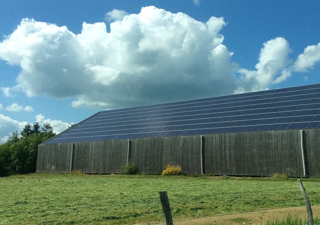 A lot of solar cell panels on a wooden building in France.